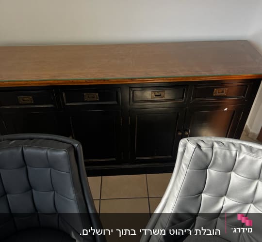 שני כיסאות עור אפורים מול שידה שחורה